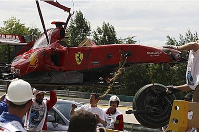 Marshals remove the Ferrari car driven by Felipe Massa after he crashed during the qualification session of the Hungarian Grand Prix at the Hungaroring circuit.