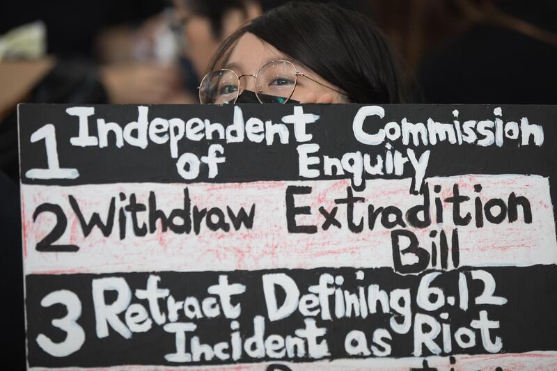 An anti-extradition bill protester holds a sign during a rally inside the arrival hall. EPA