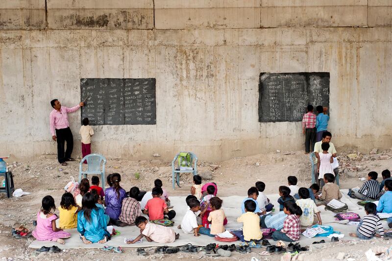 8th April 2013, Shakarpur, New Delhi, India. Rajesh Kumar Sharma (40, blue shirt) and Mr Laxmi Chandra (45, yellow shirt, seated) teach children at a makeshift school under a metro bridge near the Yamuna Bank Metro station in Shakarpur, New Delhi, India on the 8th April 2013. 

Rajesh Kumar Sharma (40), started this makeshift school a year ago. Five days a week, he takes out two hours to teach when his younger brother replaces him at his general store in Shakarpur. His students are children of labourers, rickshaw-pullers and farm workers. This is the 3rd site he has used to teach under privileged children in the city, he began in 1997 fifteen years ago. 

PHOTOGRAPH BY AND COPYRIGHT OF SIMON DE TREY-WHITE

+ 91 98103 99809
+ 91 11 435 06980
+44 07966 405896
+44 1963 220 745
email: simon@simondetreywhite.com
