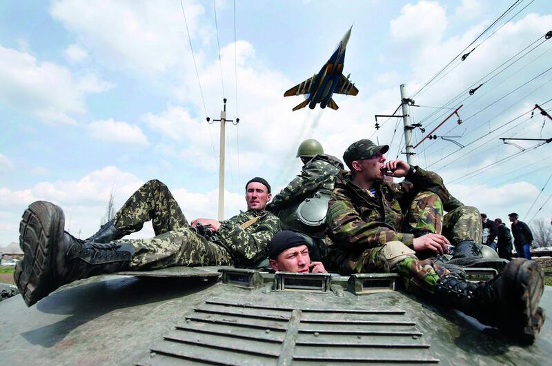 A fighter jet flies overhead as Ukrainian soldiers sit on an armoured personnel carrier in Kramatorsk, in eastern Ukraine, in this April 16 file photo.  Marko Djurica / Reuters