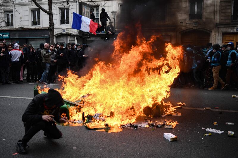 A protester ducks to avoid missiles during continuing demonstrations over the government's pension reform plan in France. AFP
