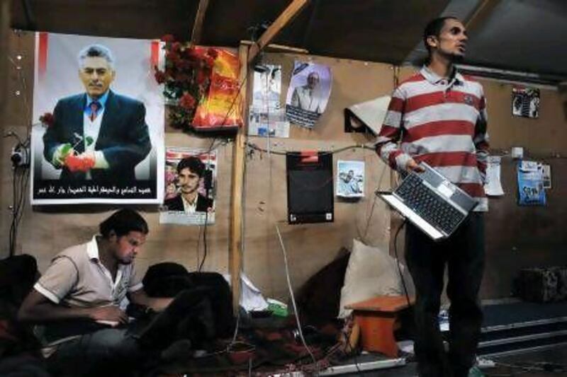 Hussein Moghram, left, and Osama Shamsan at work inside a tent that serves as a media centre in Change Square.