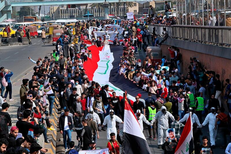 Students and other demonstrators hold national flags during ongoing anti-government protests, in Baghdad, Iraq, Sunday, Februar 23, 2020. AP Photo