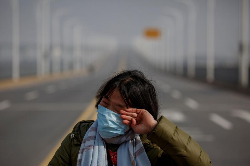 A mother reacts as she pleads with police to allow her daughter to pass a checkpoint for cancer treatment after she arrived from Hubei province at the Jiujiang Yangtze River Bridge in Jiujiang, Jiangxi province, China, as the country is hit by an outbreak of a new coronavirus, February 1, 2020.   REUTERS/Thomas Peter     TPX IMAGES OF THE DAY