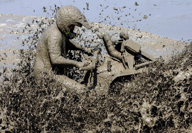 A quad biker goes through a mud pool at the International Off Road Festival in Somogybabod, Hungary. EPA