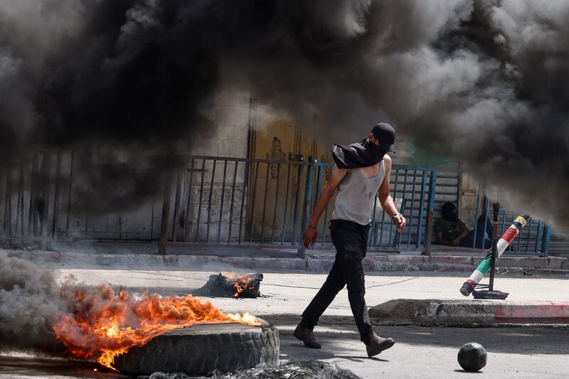 Tyres burn amid violence between Palestinian protesters and Israeli forces conducting a raid in Jenin, in the occupied West Bank. AFP