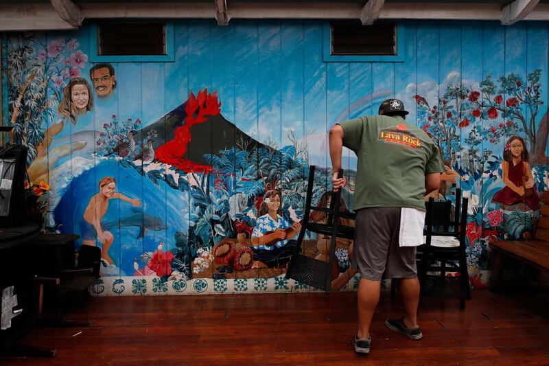 Restaurant worker William Kauhane, 20, moves chairs at Lava Rock Cafe in Volcano, Hawaii. Jae C Hong / AP Photo