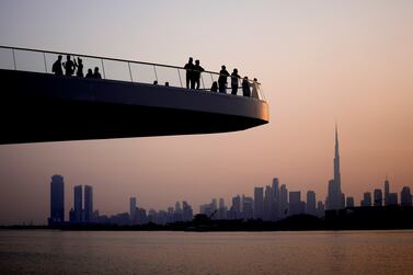 People stand on the observation deck of the Dubai Creek Harbour in Dubai, United Arab Emirates, Sunday, June 18, 2023, to view the city skyline with the world's tallest tower, the Burj Khalifa.  (AP Photo / Kamran Jebreili)