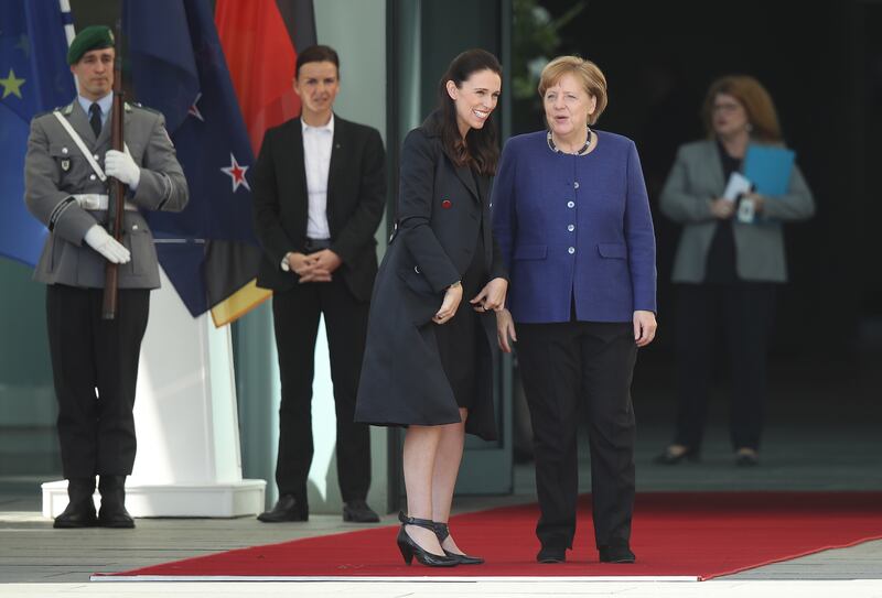 Former German chancellor Angela Merkel, right, with Ms Ardern in Berlin. Getty