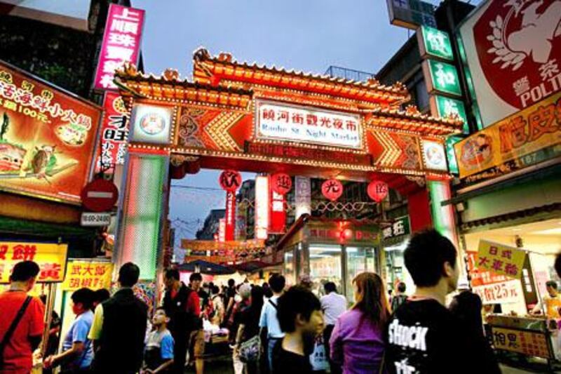 A decorated archway is lit up at a night market in Taipei, Taiwan, on Saturday, May 8, 2010. About 54 million Chinese may travel abroad this year, and a stronger yuan may boost their spending in Taiwan as the government in Beijing allows more citizens to visit the island. Photographer: Maurice Tsai/Bloomberg

 *** Local Caption ***  671866.jpg