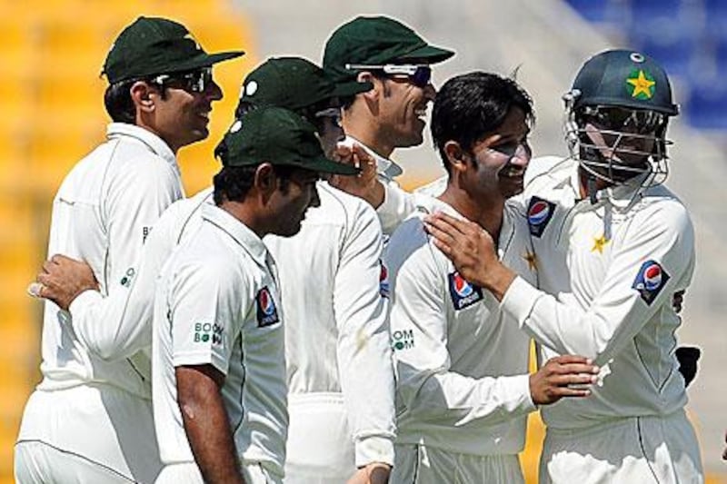 Aizaz Cheema is congratulated after he accounted for key man, Kumar Sangakkara, on the first day of the Test.