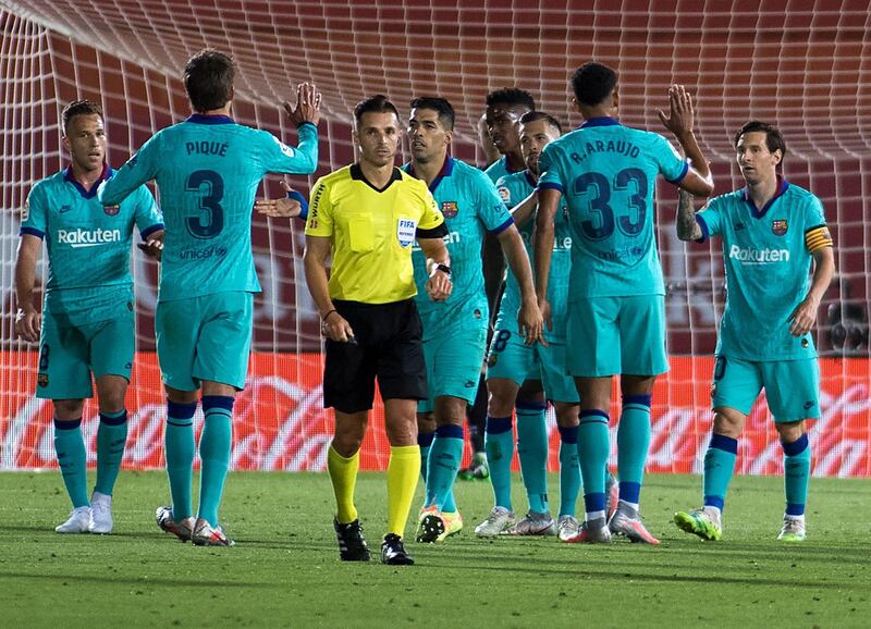 Lionel Messi (R) celebrates with teammates after scoring against Mallorca. AFP