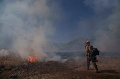 A firefighter walks towards flames from the Post Fire on June 16, 2024, in Lebec, California. AP