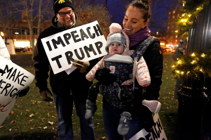 Jerry Crawford, left, of Dubuque, Iowa, and Nora Crawford and her daughter Nora, of Seattle, Wash., attend the "Nobody Is Above the Law" rally in Dubuque, Iowa.  AP