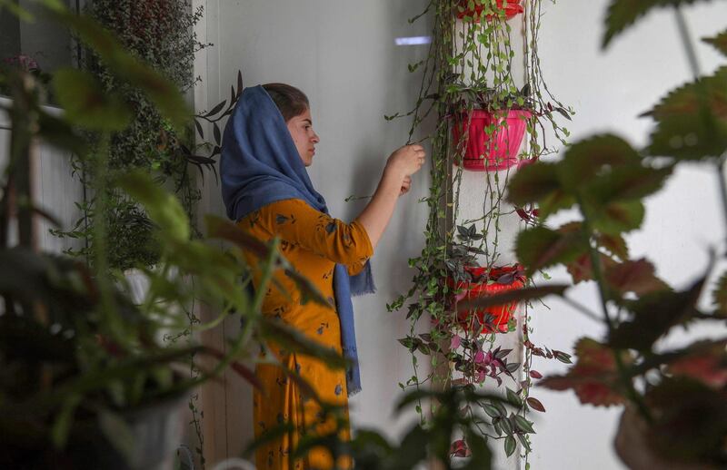 An Iranian Kurd refugee tends to her plants at the Bahrka refugee camp. Residents in the camp watched on as elections took place this week in Iran. AFP