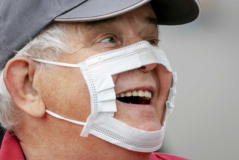 A demonstrator uses a cut out protective mask against the coronavirus restrictions measures, during a protest on the Malieveld in The Hague, Netherlands. EPA