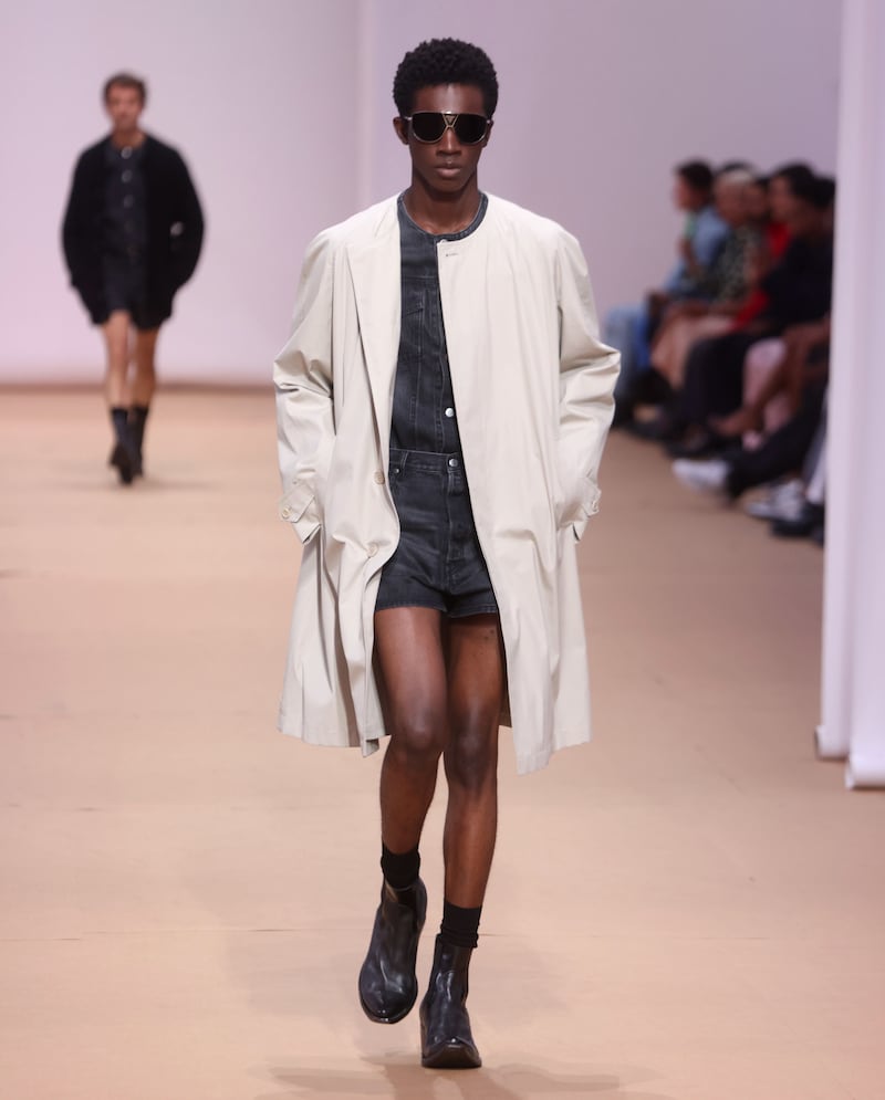 Several versions of lightweight coats graced the runway at the Prada spring/summer 2023 show, all worn with leather shorts and ankle-length cowboy boots. Photo: EPA