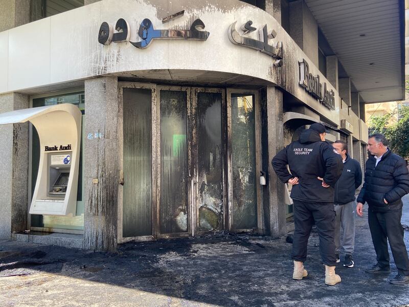 Protesters in Beirut set bank doors alight on Thursday. Nada Al Homsi / The National