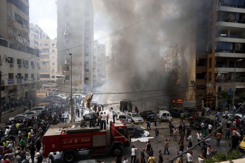 Firefighters and residents gather at the site of an explosion in Beirut's southern suburb neighbourhood of Bir al-Abed on July 9, 2013. A car bomb rocked Beirut's Hezbollah stronghold in the southern suburbs, which is populated mainly by Shiite Muslims, Lebanese television channels reported.  AFP PHOTO/STR
 *** Local Caption ***  517916-01-08.jpg