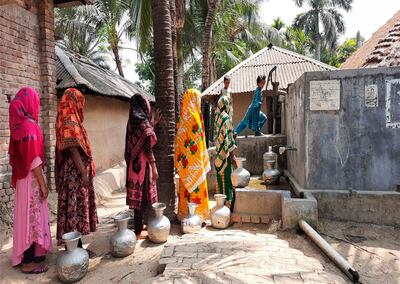 Women wait their turn to fill vessels at a clean water filtration point near their homes in Bangladesh. Photo: Ledars