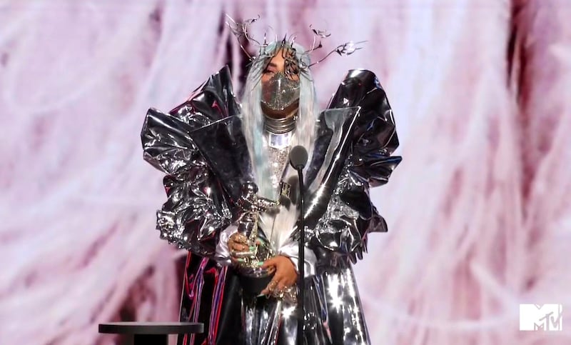 Lady Gaga, wearing a sculptural Candice Cuoco coat, Maisonmet mask and Valentino bodysuit, accepts the Tricon award during the MTV Video Music Awards. AP
