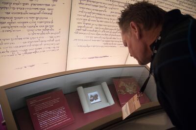 Visitors look at an exhibit about the Dead Sea scrolls during a media preview of the new Museum of the Bible, a museum dedicated to the history, narrative and impact of the Bible, in Washington, DC, November 14, 2017. (Photo by SAUL LOEB / AFP)