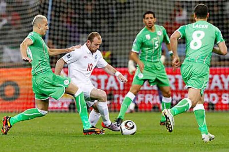 Wayne Rooney, centre, tries to find a way through the Algerian defence at Green Point Stadium in Cape Town.