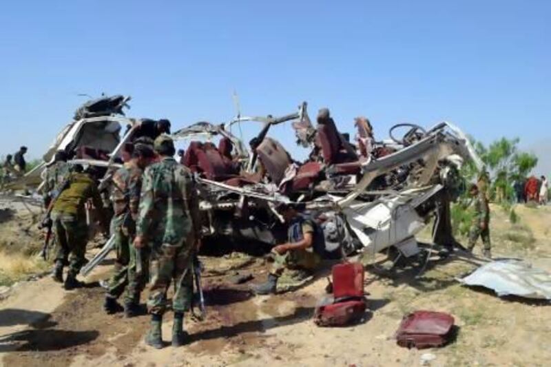 Pakistani security officials examine the destroyed vehicle used by security forces following a bomb attack on the outskirts of Quetta, the capital of restive Baluchistan province, on May 23, 2013. A bomb planted in a rickshaw tore through a vehicle used by security forces in southwest Pakistan on May 23, killing at least 12 people, police said. AFP PHOTO / BANARAS KHAN