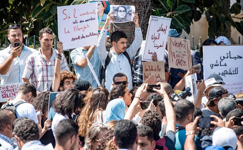 Demonstrators hold up signs showing the portraits of Hajar Raissouni, a Morrocan journalist of the daily newspaper Akhbar El-Youm, as they gather outside a courthouse holding her trial on charges of abortion in Marrakesh.  AFP