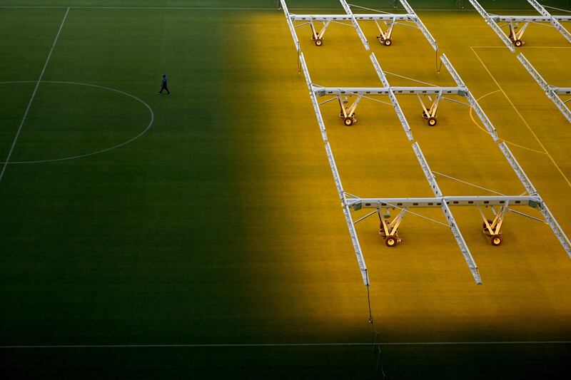 A man works on the pitch of the Lusail Stadium. AFP