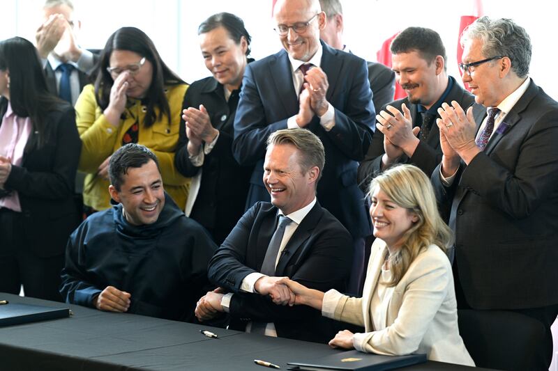 Greenland Prime Minister Mute Bourup Egede, left, Denmark's Minister for Foreign Affairs Jeppe Kofod, center, and Canada's Minister of Foreign Affairs Melanie Joly share a three-way handshake after signing an agreement that will establish a land border between Canada and Denmark on Hans Island, an Arctic island between Nunavut and Greenland, Tuesday, June 14, 2022, in Ottawa.  (Justin Tang / The Canadian Press via AP)