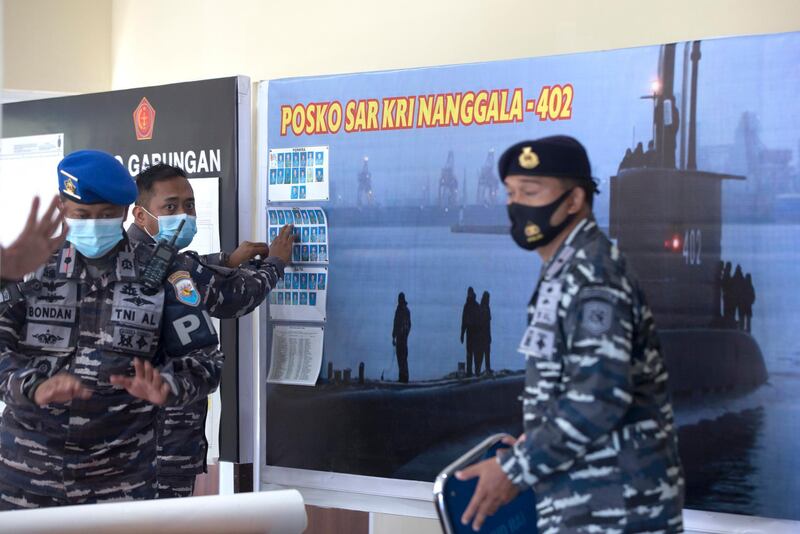A military officer puts up on the wall the pictures of the crew members of the missing Indonesian Navy submarine KRI Nanggala. EPA
