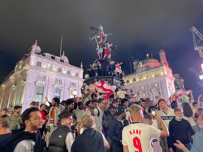 England fans climb the statue of Eros in Piccadilly Circus.
