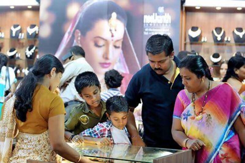 A family looks at a display of gold jewellery in Bangalore. India's government increased the import duty on gold to curb high demand. Manjunath Kiran / AFP