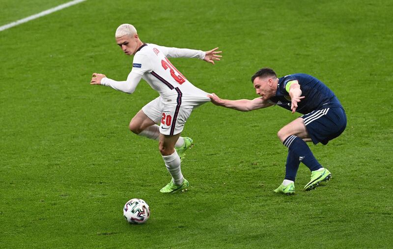 England's Phil Foden has his shorts pulled by Andrew Robertson of Scotland. Reuters