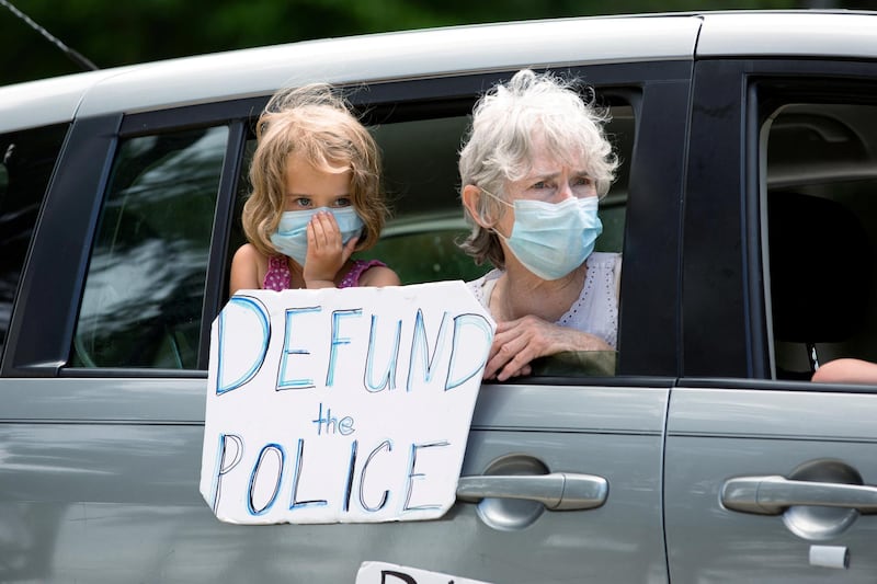 A grandmother and granddaughter hold a sign and look on as protesters march against the Confederate Monument carved into granite at Stone Mountain Park in Stone Mountain, Georgia, U.S. REUTERS