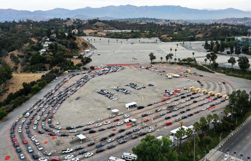Vehicles line up to enter a testing site at Dodger Stadium on the first day of new stay-at-home orders in Los Angeles, California.   AFP