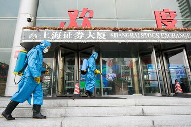 Medical workers spray antiseptic outside the main gate of the Shanghai Stock Exchange Building. The Shanghai Composite index dropped 8 per cent on Monday as traders returned from the Lunar New Year holidays on investor concerns about the spread of the coronavirus. Getty Images.
