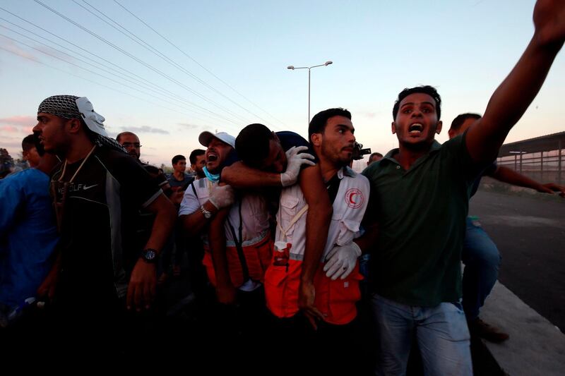 Palestinian protesters carry away a wounded demonstrator at the Erez crossing with Israel in the northern Gaza Strip. AFP