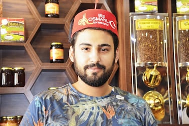 Syrian worker Husam Kiyat, who works at Syrian-owned Olabi Kahvesi, wears a fez embroidered with the phrase “We are Ottoman grandsons”. Many in the city of Mersin say they are is struggling to retain the traditional spirit of tolerance as the arrival of refugees from Syria has ballooned. Necdet Tas for The National