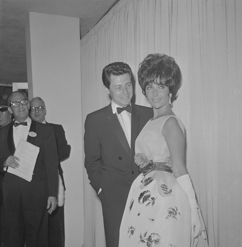 (Original Caption) Elizabeth Taylor and her new husband, Eddie Fisher, pause to smile broadly before entering the Santa Monica Civic Auditorium, April 17th, for the Academy Award presentations. Miss Taylor has been nominated for the Best Actress award for her leading role in "Butterfield 8." Getty Images