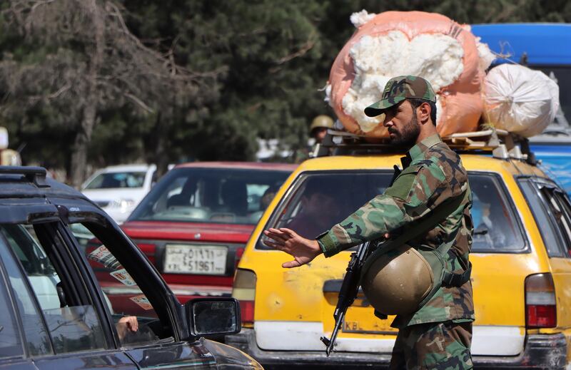 Taliban fighters, wearing the uniform of the former Afghan army, check drivers in Kabul. EPA