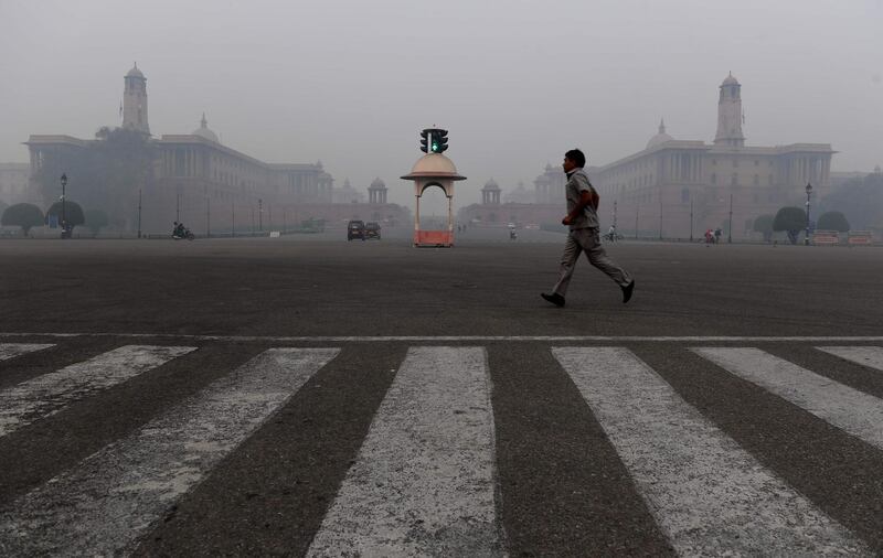 A man crosses a street near government offices amid heavy smog in New Delhi. AFP