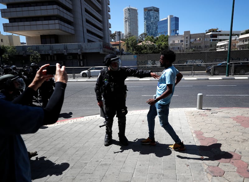An Israeli police officer and an Eritrean demonstrator in Tel Aviv on Saturday. EPA