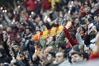 A Galatasaray supporter holds his scarf at the start of a Europa League football match between Galatasaray and Barcelona in Istanbul in March.  AFP