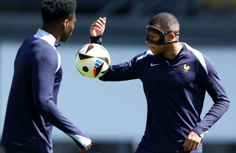 Kylian Mbappe, wearing a protective mask, takes part in a training session at the Home Deluxe Arena Stadium in Paderborn, western Germany, on June 24, 2024. AFP