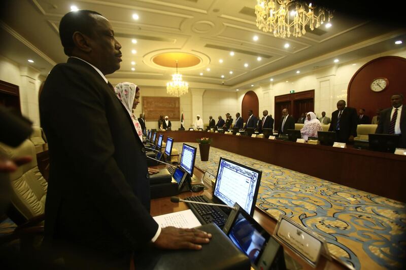 The new Sudanese ministers take the oath of office at the presidential palace in the capital of Khartoum on September 15 2018.  Sudan's new 21-member cabinet was sworn in yesterday, with Prime Minister Moutaz Mousa Abdallah also assuming the finance portfolio in a bid to revive the country's ailing economy. Bashir said the people of Sudan had "high hopes" from the new government. / AFP / ASHRAF SHAZLY
