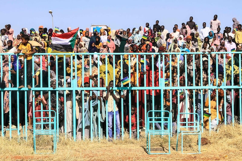 People watch as fighters of a rebel group active in Darfur attend a pass-out parade in Sudan's south-eastern Gedaref state. The rebel group, the Sudan Liberation Movement, supports army chief Gen Abdel Fattah Al Burhan. AFP