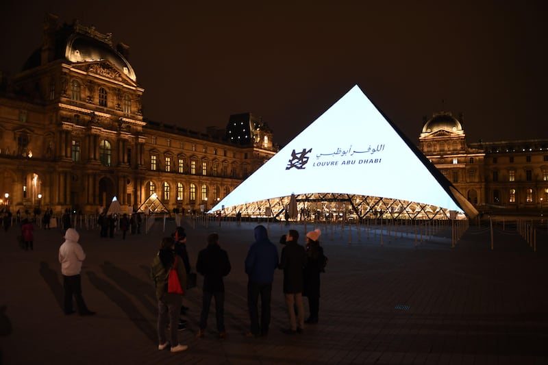 Images are projected onto the Louvre Pyramid in Paris on Wednesday to mark the opening of the Louvre Abu Dhabi on Saadiyat island in the UAE's capital. Eric Feferberg / AFP