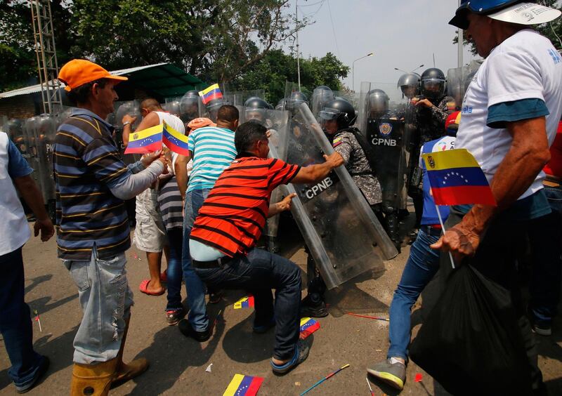 Supporters of Venezuela's opposition leader Juan Guaido struggle with police standing guard at the Francisco de Paula Santander International Bridge. AFP